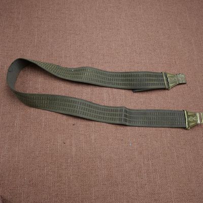 une paire de Webbs vert militaire avec des boucles en laiton sur fond marron