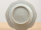 a white plate with a gold rim sitting on a table