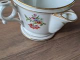 une tasse blanche à bord doré posée sur une table en bois