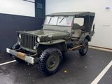 une jeep verte garée sur un parking à côté d'un immeuble