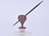 a small glass jar with a pen on top of it