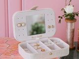 a jewelry box with a mirror on top of a table