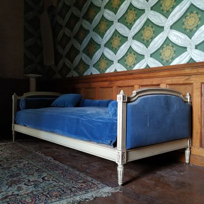 un lit recouvert d'un drap bleu dans une chambre