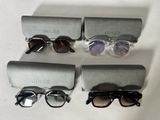 three pairs of sunglasses are sitting on a table next to a pair of glasses
