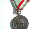 une médaille d'argent entourée d'un ruban rouge et blanc