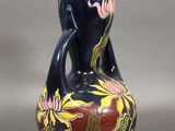 un vase bleu orné d'un motif rouge et jaune