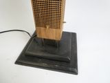 une petite radio en bois posée sur un support, avec un cordon d'alimentation
