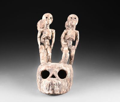 un gros plan d'une sculpture représentant deux personnes sur un crâne