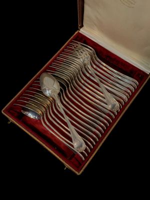 des couverts dans un coffret doublé de velours rouge sur fond noir