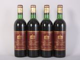 three bottles of red wine are lined up on a table