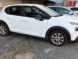 a white car parked in a parking lot next to other cars