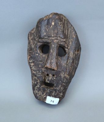 un gros plan d'un masque en bois muni d'une étiquette