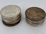 two stacks of coins sitting next to each other on a white surface