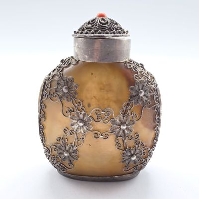 un vase ancien en argent et en or, surmonté d'une perle rouge