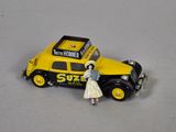 une petite voiture jaune à côté de laquelle se tient une femme