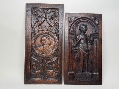 deux plaques en bois sur lesquelles sont sculptés un homme et une femme