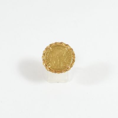 l'image d'une bague en or sur laquelle se trouve une pièce de monnaie