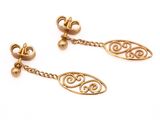 une image d'une paire de boucles d'oreilles en or sur fond blanc