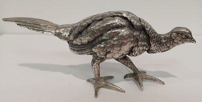 un oiseau argenté posé sur une surface blanche