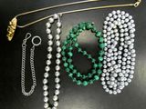 a close up of a bunch of beads and chains on a table
