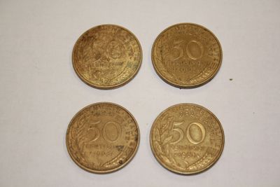 four gold coins sitting on top of each other on a white surface