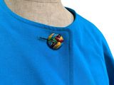 blue dress with a colorful brooch on the neck