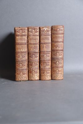 three old books are stacked on top of each other on a table