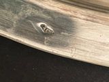 a close up of a silver plate with a small bug on it