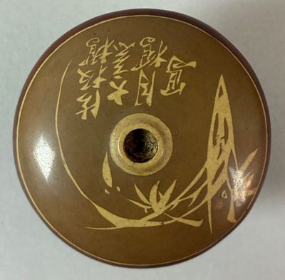 a brown and gold vase with asian writing on it