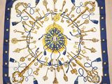 a blue and white scarf with gold keys and keys on it