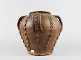 an old brown vase sitting on top of a white surface