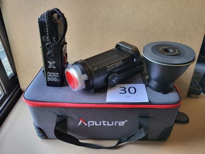un sac sur lequel sont posés un appareil photo, une lampe de poche et d'autres objets