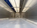 un long couloir avec un plafond bleu et un sol blanc