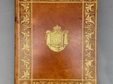 un vieux livre orné d'un emblème doré, posé sur une table