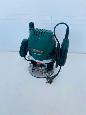 a close up of a green electric router on a white surface