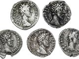quatre pièces de monnaie romaines antiques, dont l'une représente la tête d'une femme et l'autre celle d'un homme