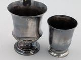 deux tasses en argent posées l'une à côté de l'autre sur une table
