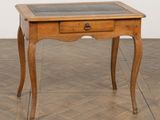 une petite table en bois avec un plateau en verre, posée sur un parquet
