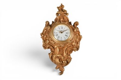 une image représentant une horloge dorée posée sur une surface blanche, sur fond blanc