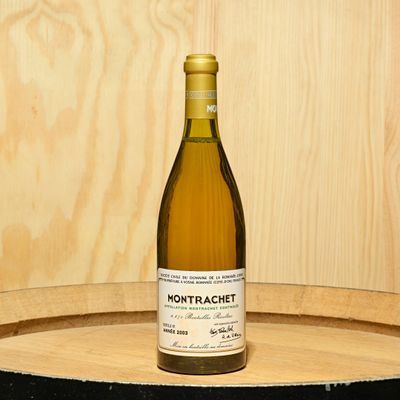 a bottle of wine sitting on top of a barrel