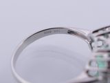 a close up of a ring with a green stone in it