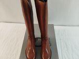 pair of brown boots sitting on top of a box on a white surface