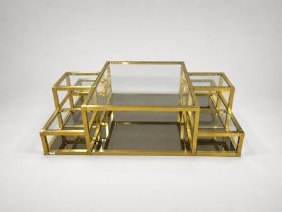 a set of three brass and glass coffee tables on a white background