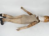 an old wooden doll laying on its side on a white surface