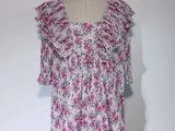 Haut à fleurs rose et blanc avec des volants, présenté sur un mannequin