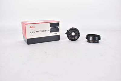 an image of a camera lens with a box of lenses in the background