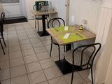 tables and chairs in a small room with white walls