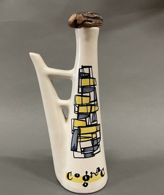 un vase blanc sur lequel sont posés des livres, sur fond gris