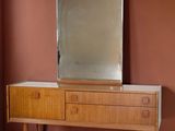 une commode en bois surmontée d'un miroir