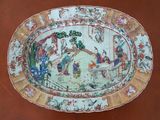 a plate with a painting on it sitting on a table